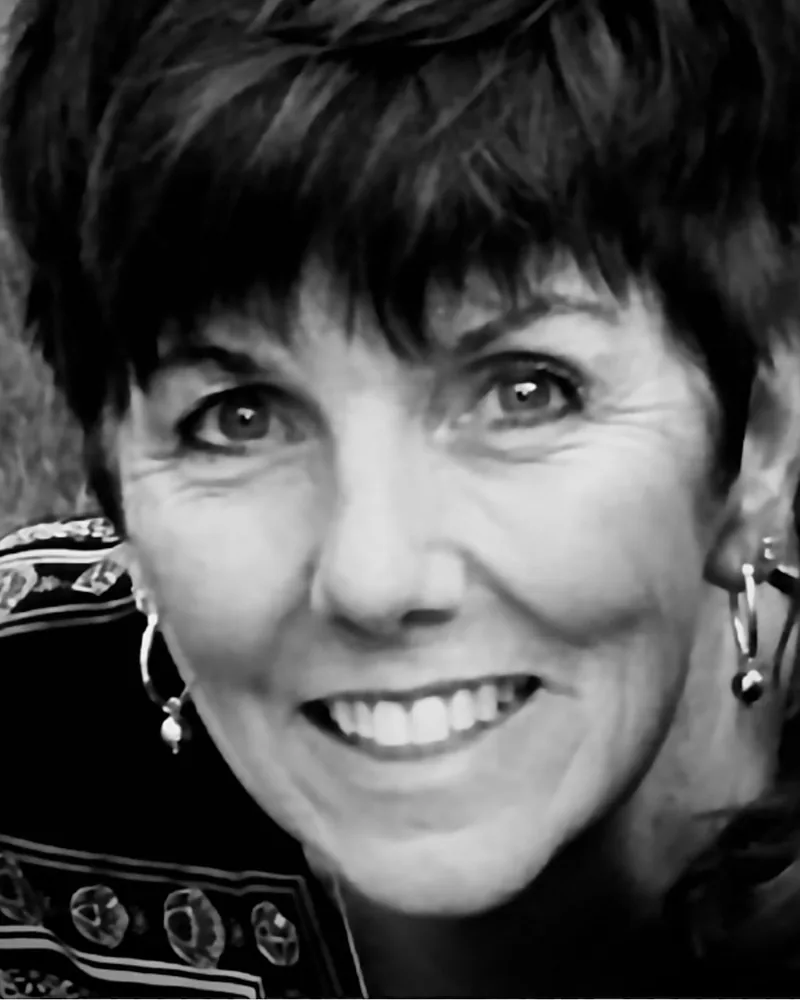Paula C. Stapleton, artist and art educator at The Boston Artistry, smiling in a black and white portrait