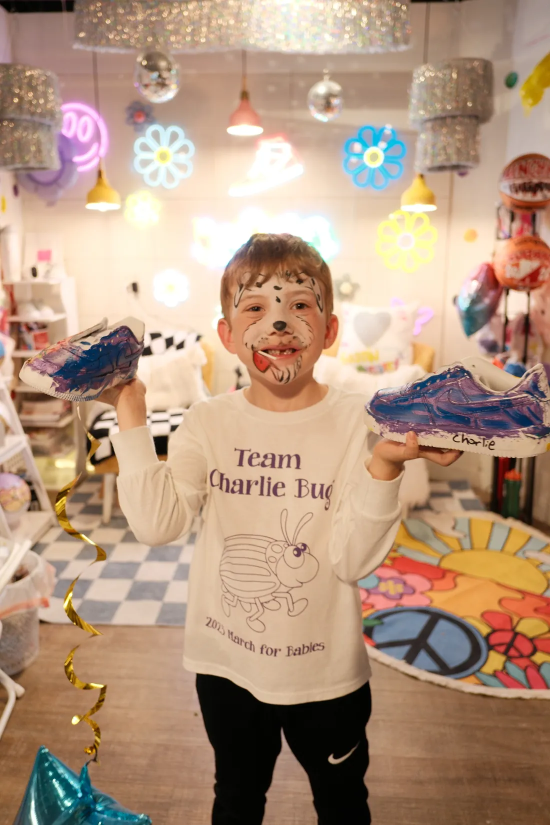 A boy shows off the sneakers he painted
