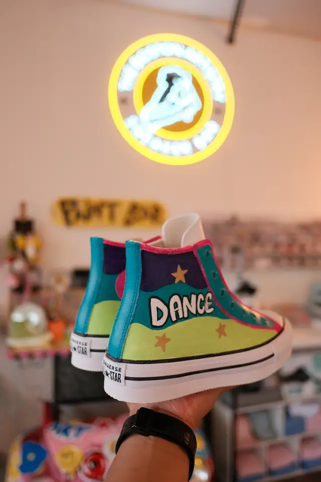 Platform high top sneakers hand painted in teal, purple and lime with gold stars and the word dance