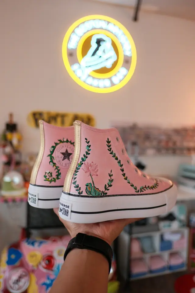 Pink painted platform high top sneakers decorated with green vines