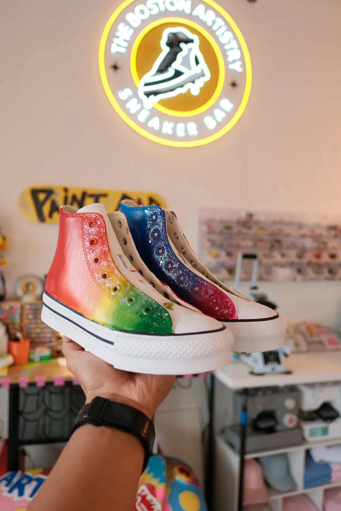 White high tops painted with rainbows, hearts and glitter