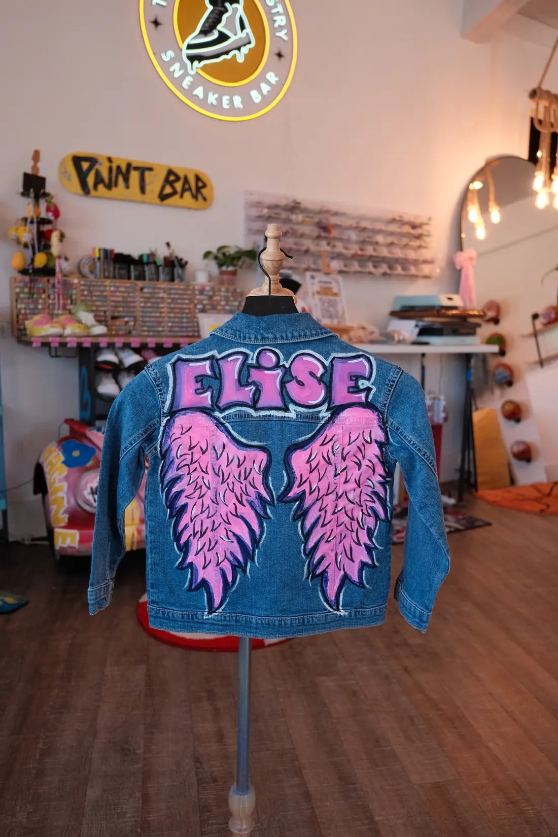 A denim jacket painted with angel wings on the back