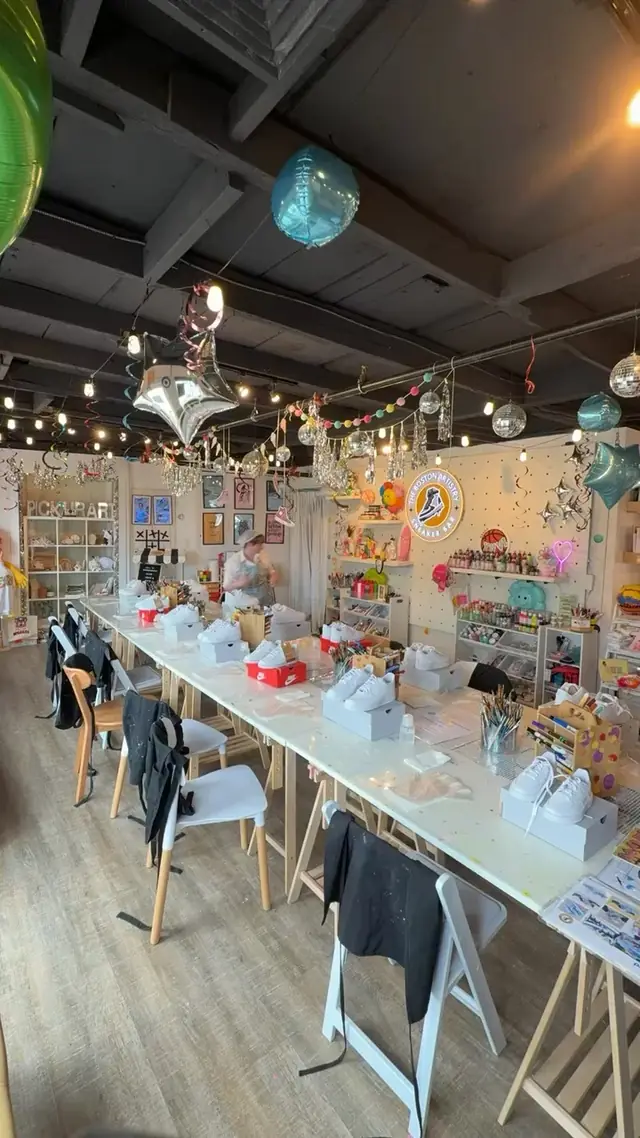 The empty studio set for a sneaker session, white sneakers on their boxes along the long table under balloons